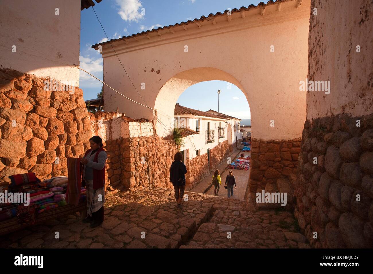 Proveedor y turistas en el centro de la aldea de Chinchero en el Valle Sagrado, Cusco, Perú, América del Sur Foto de stock