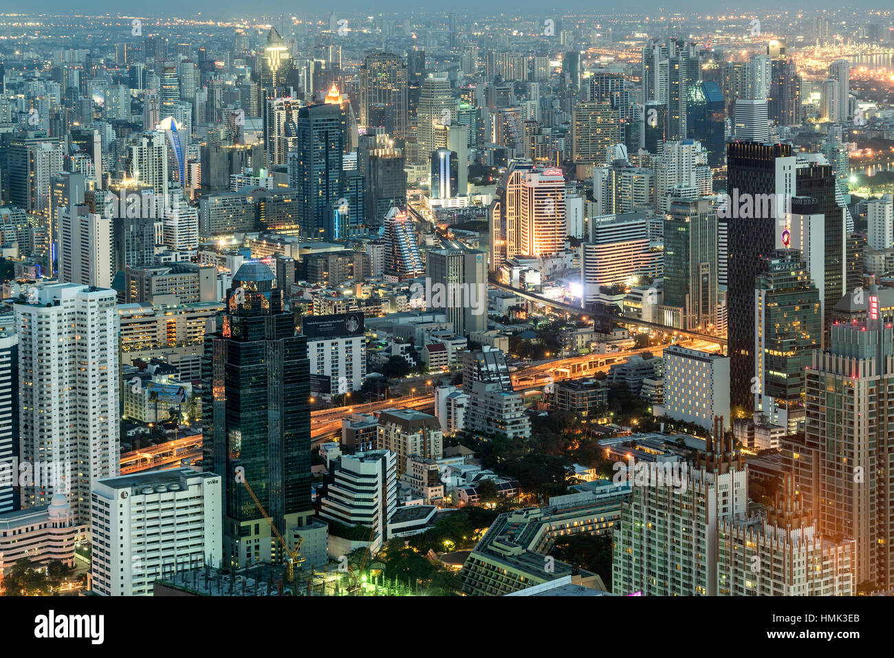 Skyline con rascacielos, iluminada calle, ciudad al anochecer, Bangkok, Tailandia Foto de stock