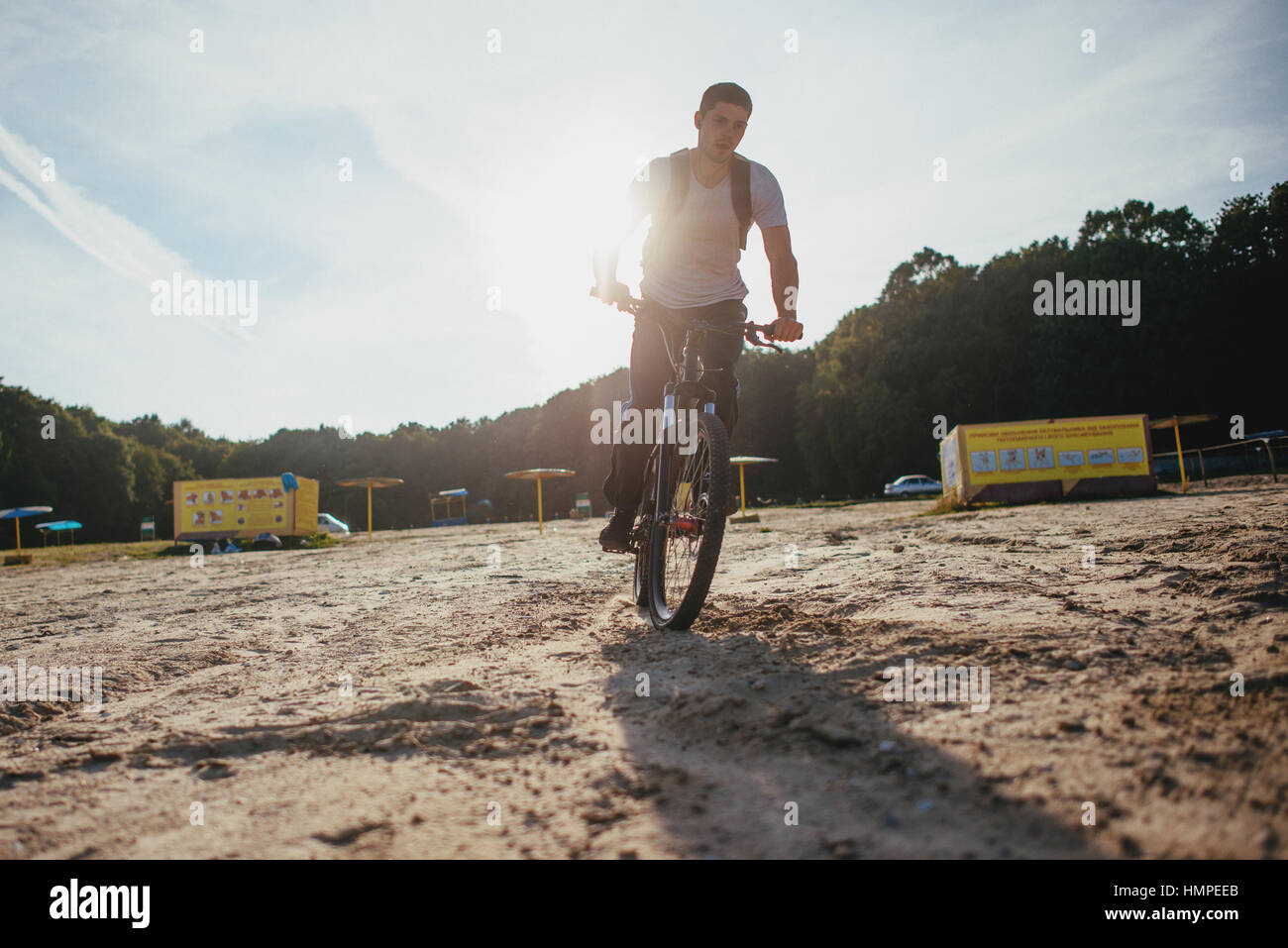 Biker montar a caballo por la playa al atardecer Foto de stock