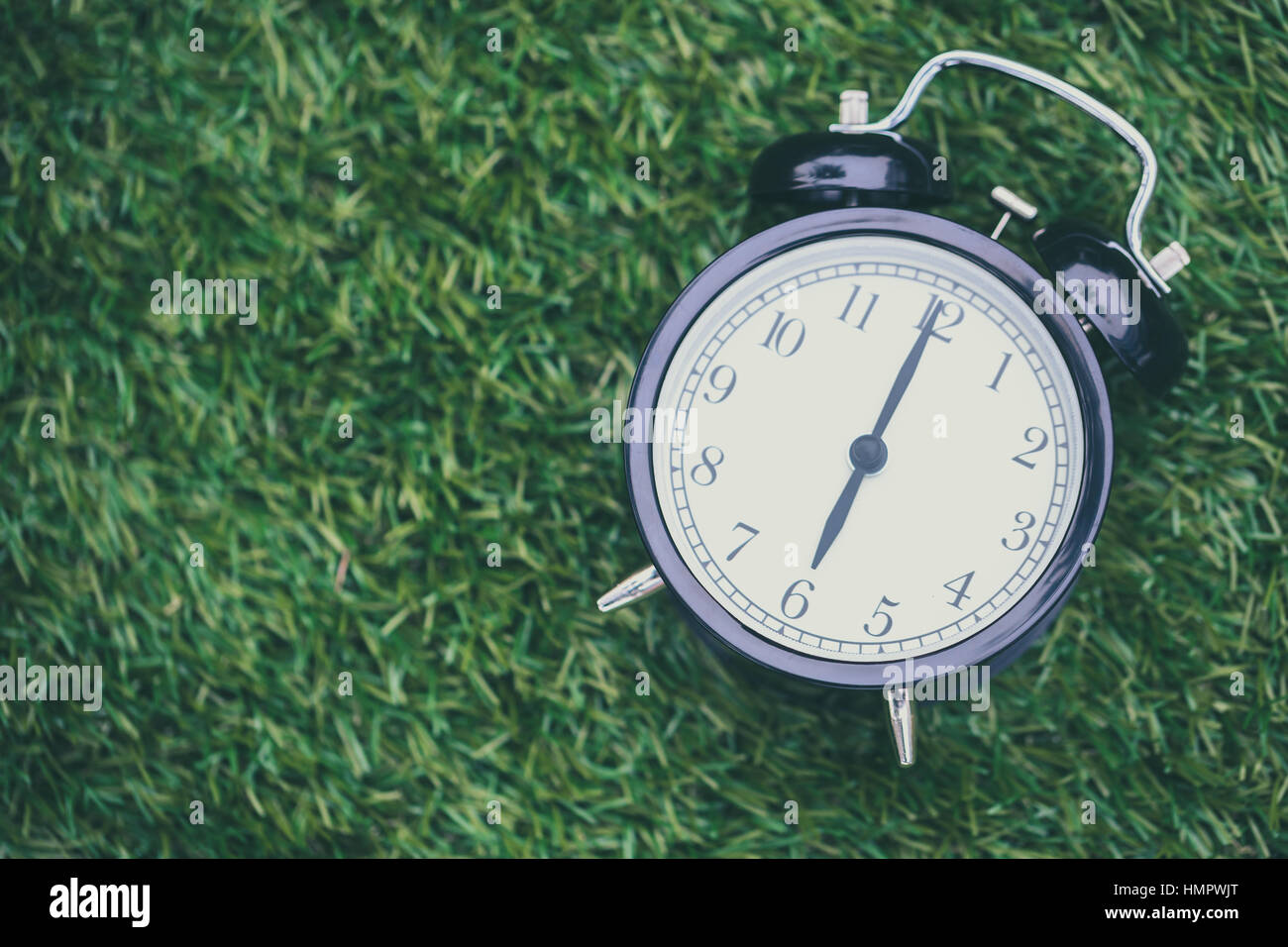 Veces Reloj retro yacía en el pasto verde naturaleza cara sincronizados de 6  o'clock mañana tiempo de fondo o postal Fotografía de stock - Alamy