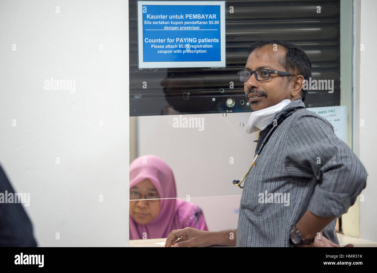 Un médico indio está esperando que una enfermera en el dispensario del hospital le dé la medicina a los pacientes en el Hospital Raja Isteri Pengiran Anak Saleha en Darussalam, Brunei. © Time-Snaps Foto de stock