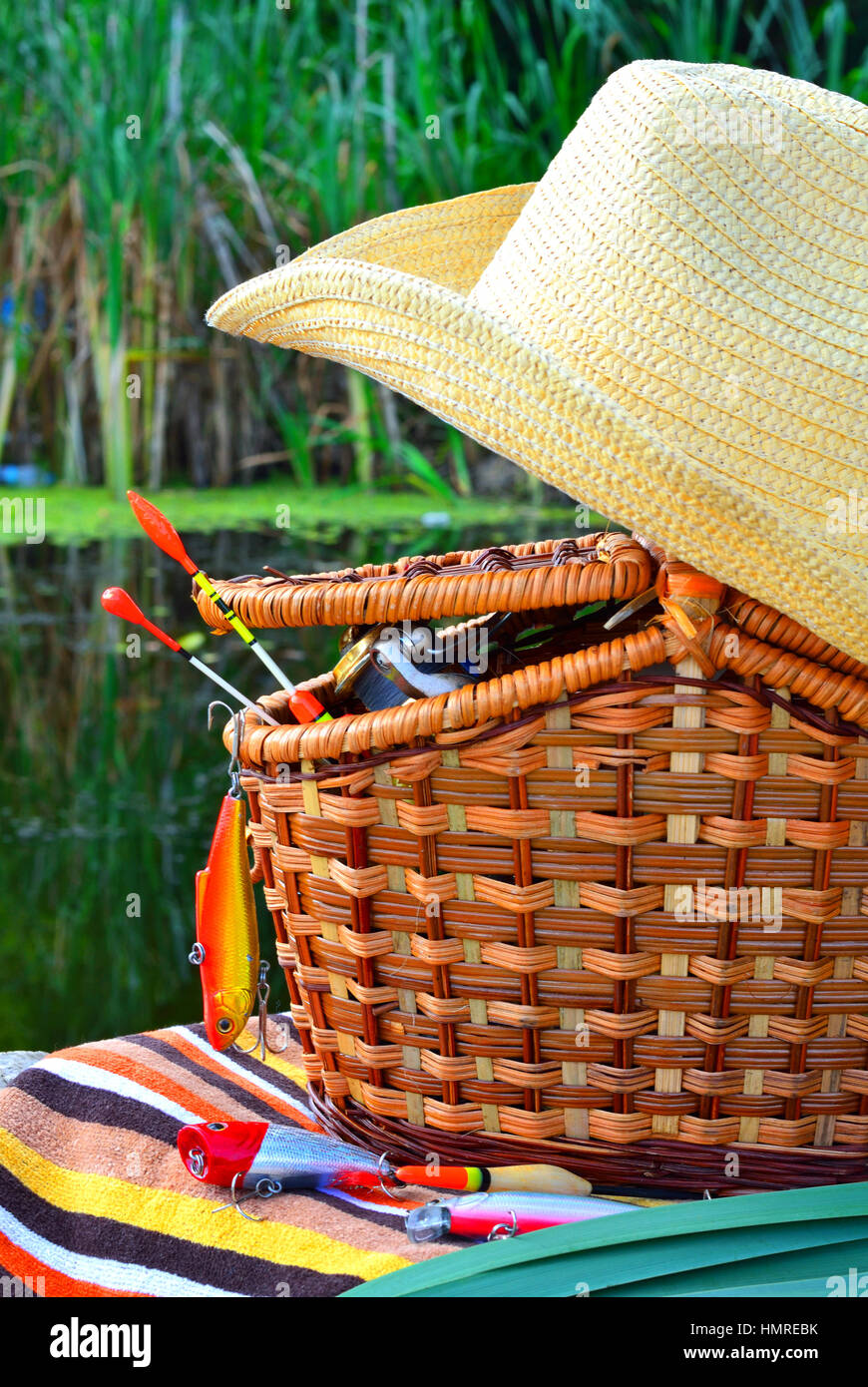 Sombrero de Cowboy, aparejos de pesca, toallas y cesta de mimbre en la  naturaleza Fotografía de stock - Alamy
