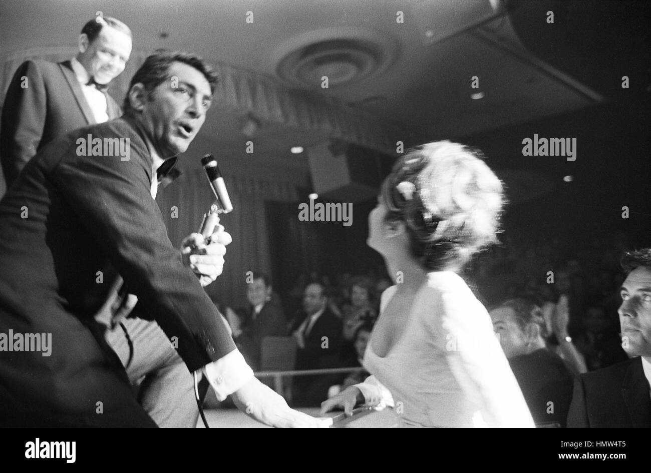 Nancy Sinatra, en la audiencia, es saludo por Dean Martin y su padre Frank Sinatra, que están en la etapa de realizar. La escena tuvo lugar en abril de 1966, en Las Vegas. Foto de stock