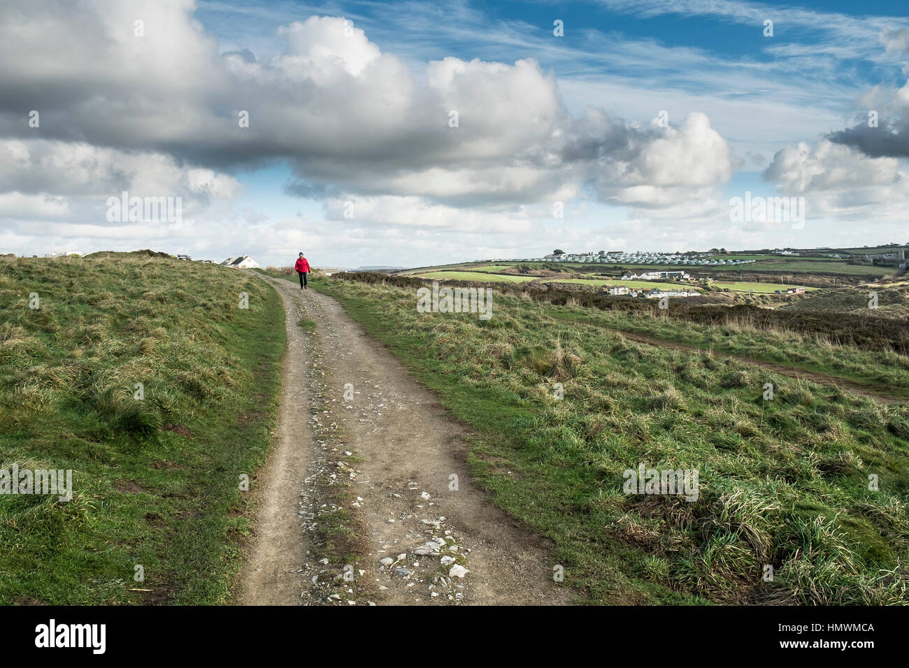 Walker chaqueta roja caminando ruta costera Oriente Pentire Headland Newquay Cornwall Foto de stock