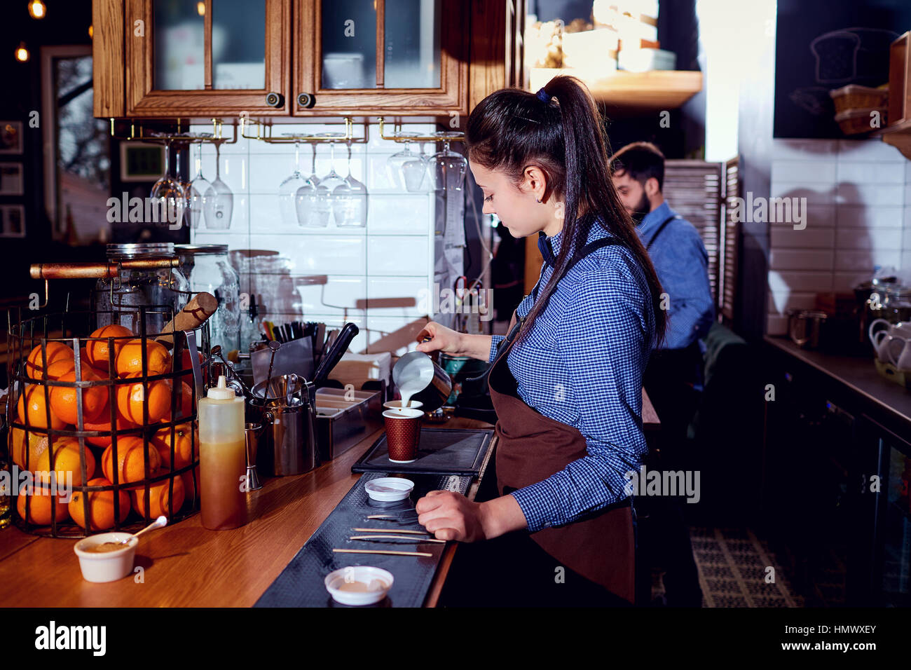 El barman barista girl hace leche caliente en el bar cafetería res Foto de stock