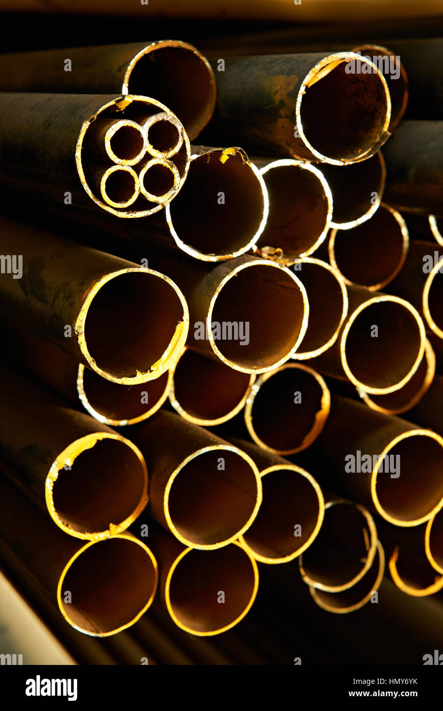 Tubos de acero redondo amarillo oxidado en el almacén Foto de stock