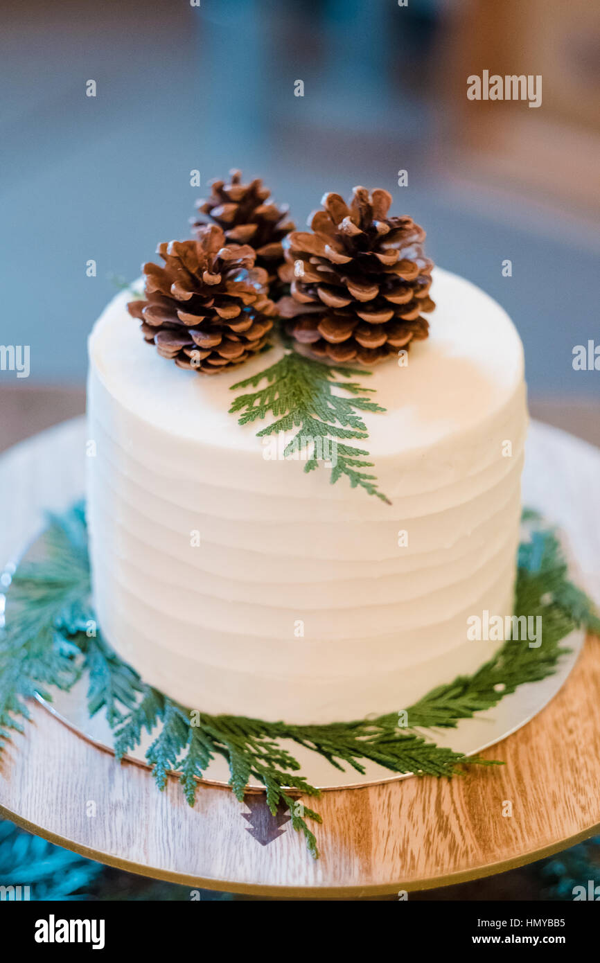 Pastel de boda blanca en una recepción con un pinecone despuntador. Foto de stock