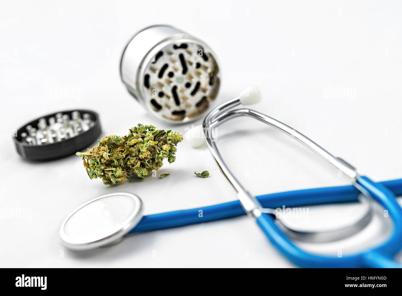 Cannabis con una amoladora y un estetoscopio delante de un fondo blanco. Foto de stock