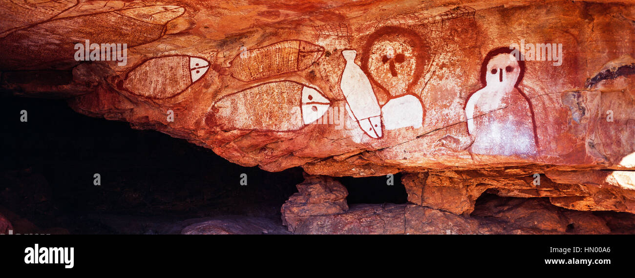 Los ricos colores ocres de una galería de pintura rupestre aborigen con el gran pez Chase. Foto de stock