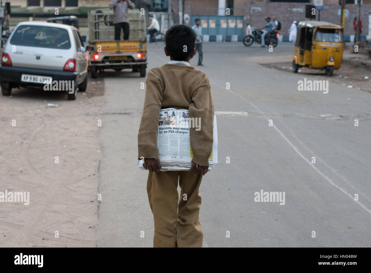 HYDERABAD, India - Enero 01,2012 En una mañana de principios de invierno,un niño indio lleva los periódicos para su entrega en Hyderabad, India Foto de stock