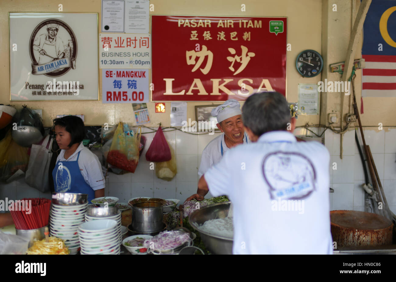 Los trabajadores ocupados en la famosa asam laksa calado de fideos en