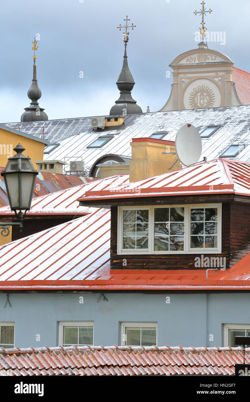 Vilna, Lituania - Enero 3, 2017: Los tejados cubiertos de nieve y la parte superior de la Iglesia Museo de patrimonio en el fondo Foto de stock
