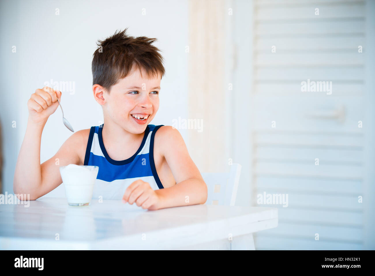 Retrato de sonriente niño se niega a comer delicioso yogur Foto de stock