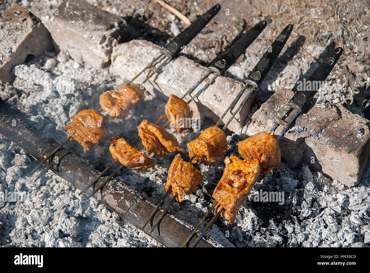 Carne asada a las brasas y troncos Fotografía de stock - Alamy