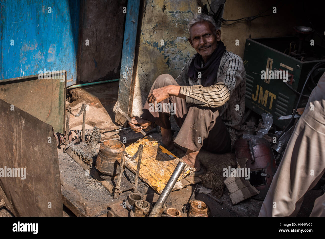 Hombre indio reparar objetos metálicos, Agra Bazar Foto de stock