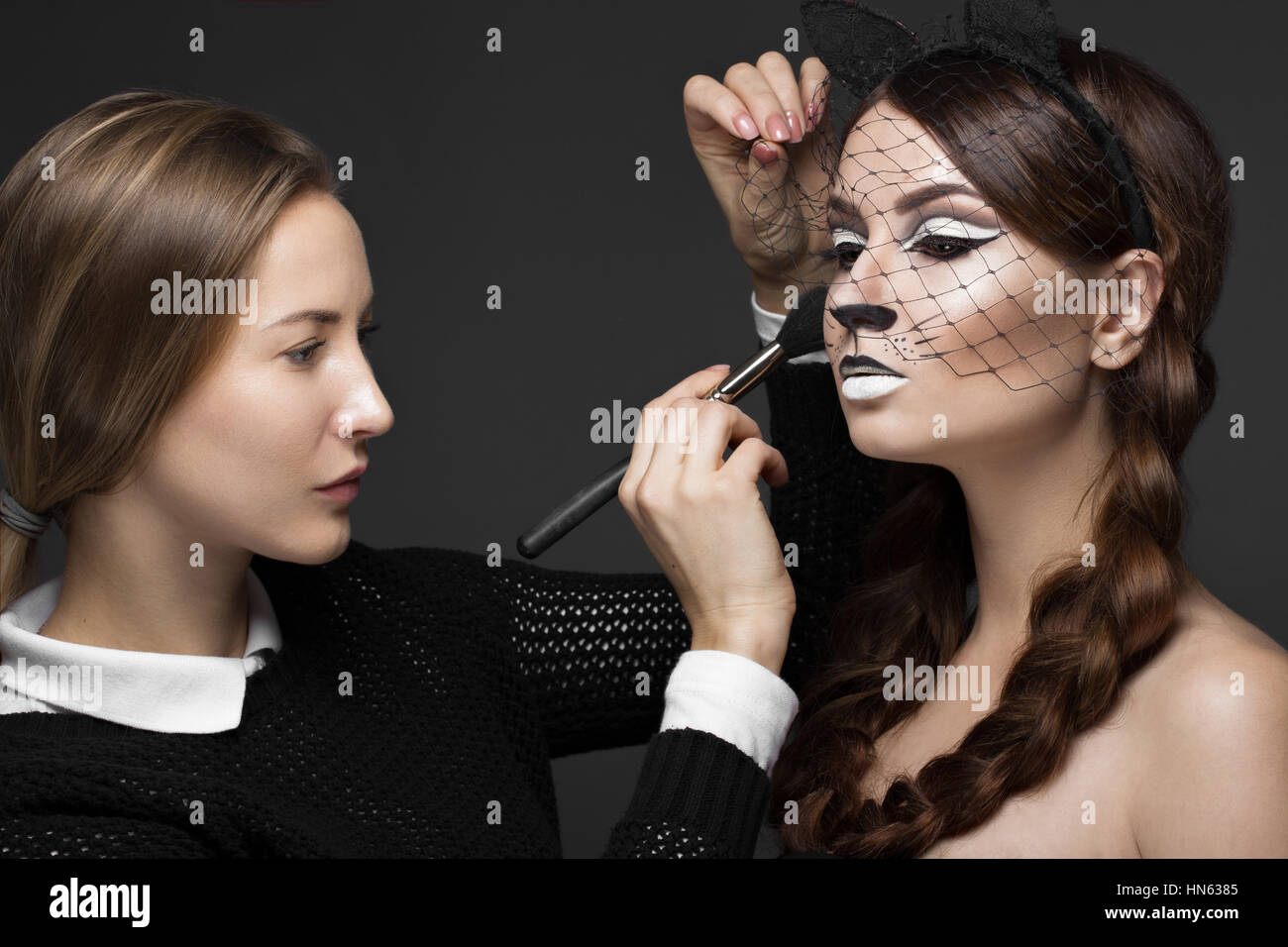 Dos chicas guapas en photo shoot para aplicar maquillaje de cara . Modelo  de moda de belleza Fotografía de stock - Alamy