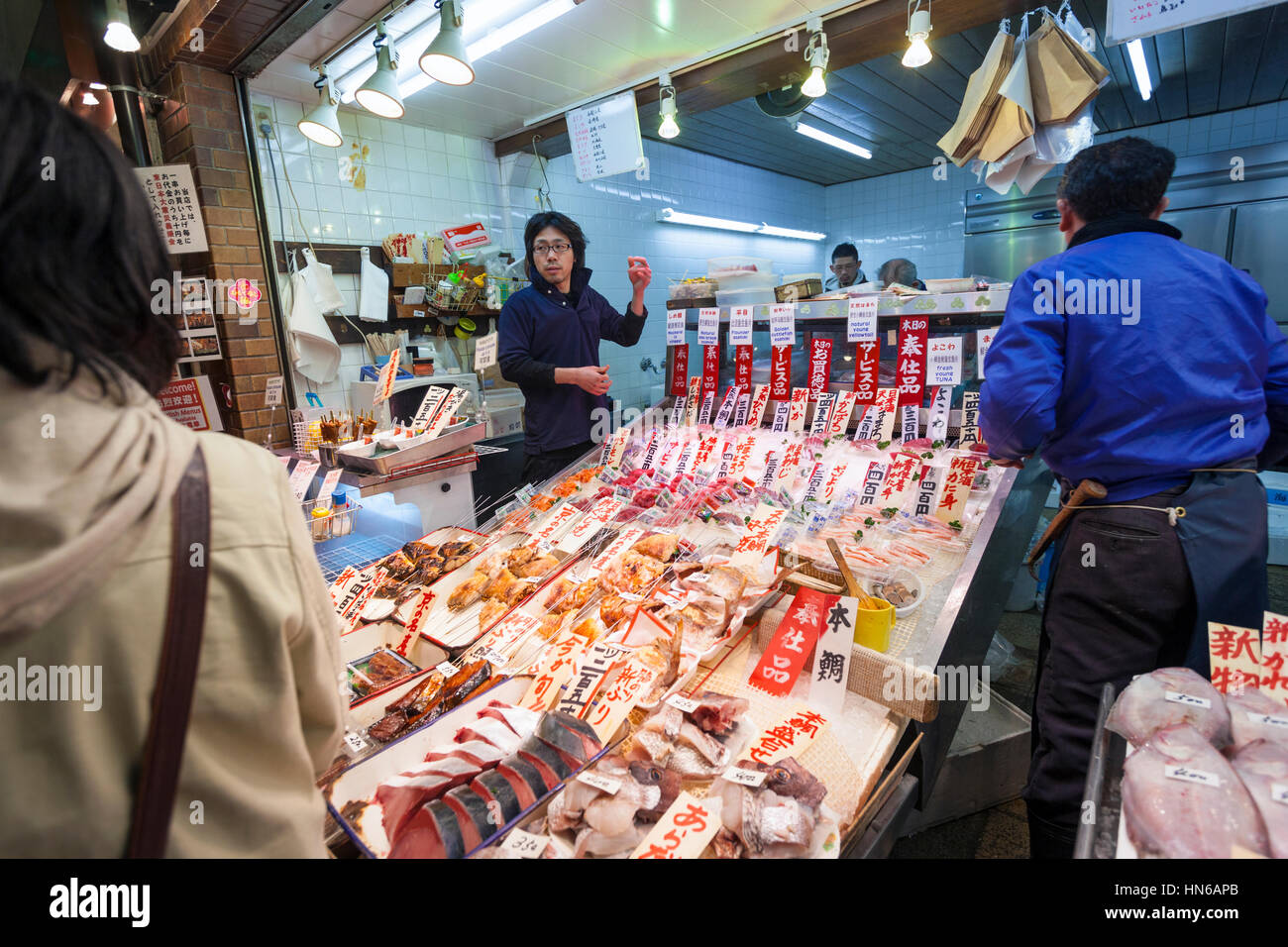 KYOTO, Japón - 23 de marzo: el personal y los clientes en un puesto de venta de pescado en el mercado de alimentos Nishiki en el centro de Kyoto el 23 de marzo de 2012. Foto de stock