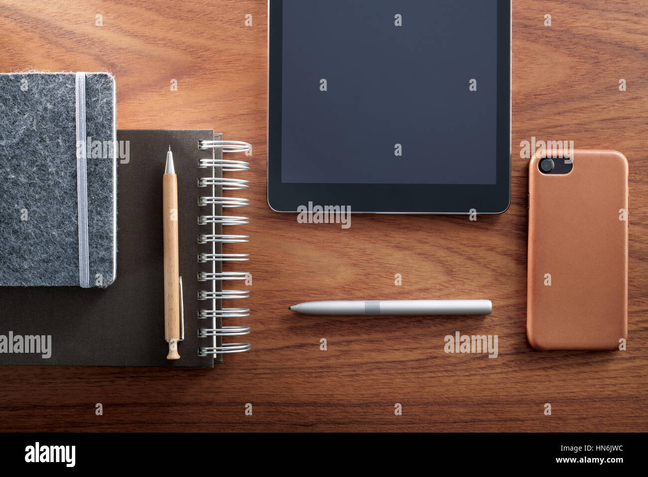 Tableta Digital, Smartphone, Bloc de notas, lápiz y bolígrafo, y en el mostrador de madera. Vs analógico digital. Foto de stock