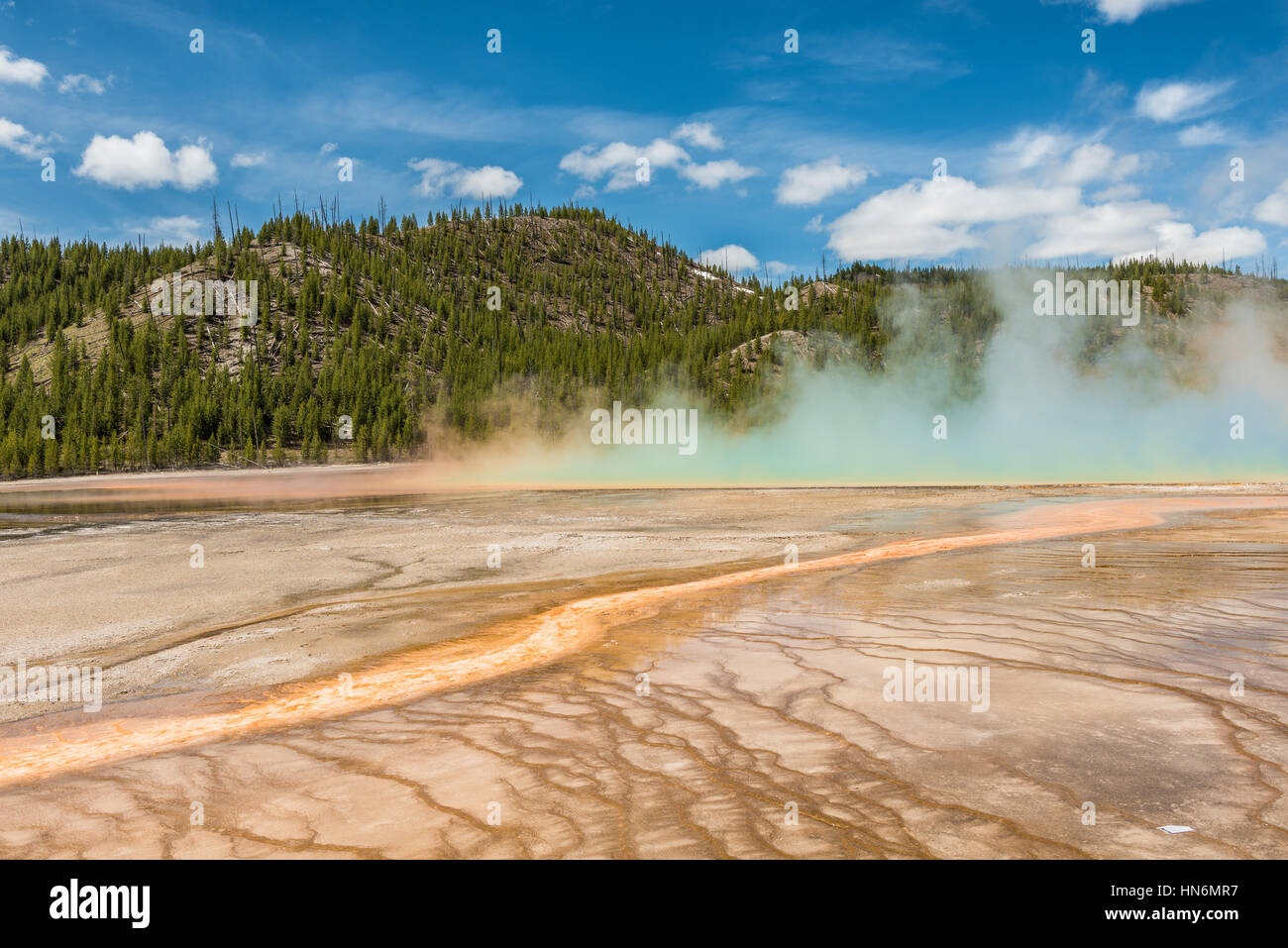 Aumento de vapor y neblina azul de Grand Prismatic hot spring en Midway Geyser basin en el Parque Nacional de Yellowstone con patrones bacterianos rojo Foto de stock