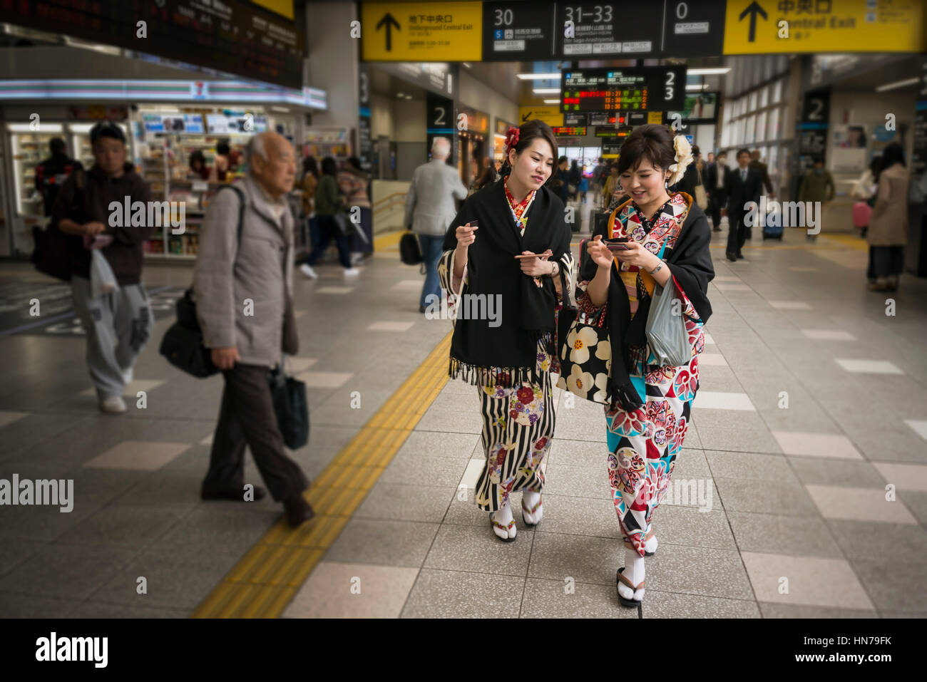 Dos jóvenes mujeres orientales vistiendo trajes tradicionales japoneses Kimono, la explanada de la estación de Kioto, Japón Foto de stock