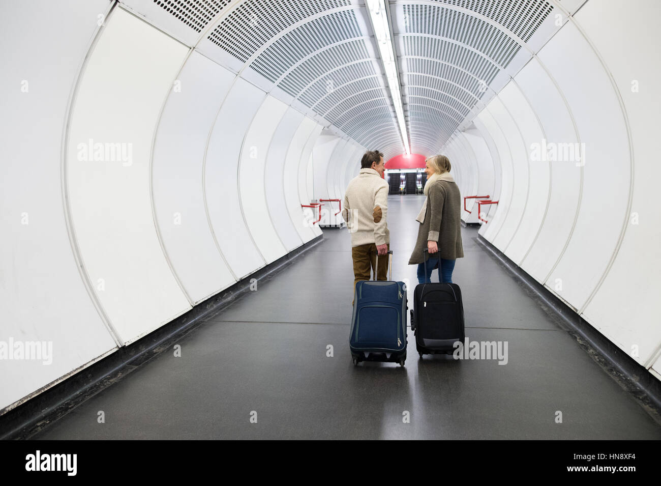 Las parejas ancianas en pasillo del metro jalando maletas trolley  Fotografía de stock - Alamy