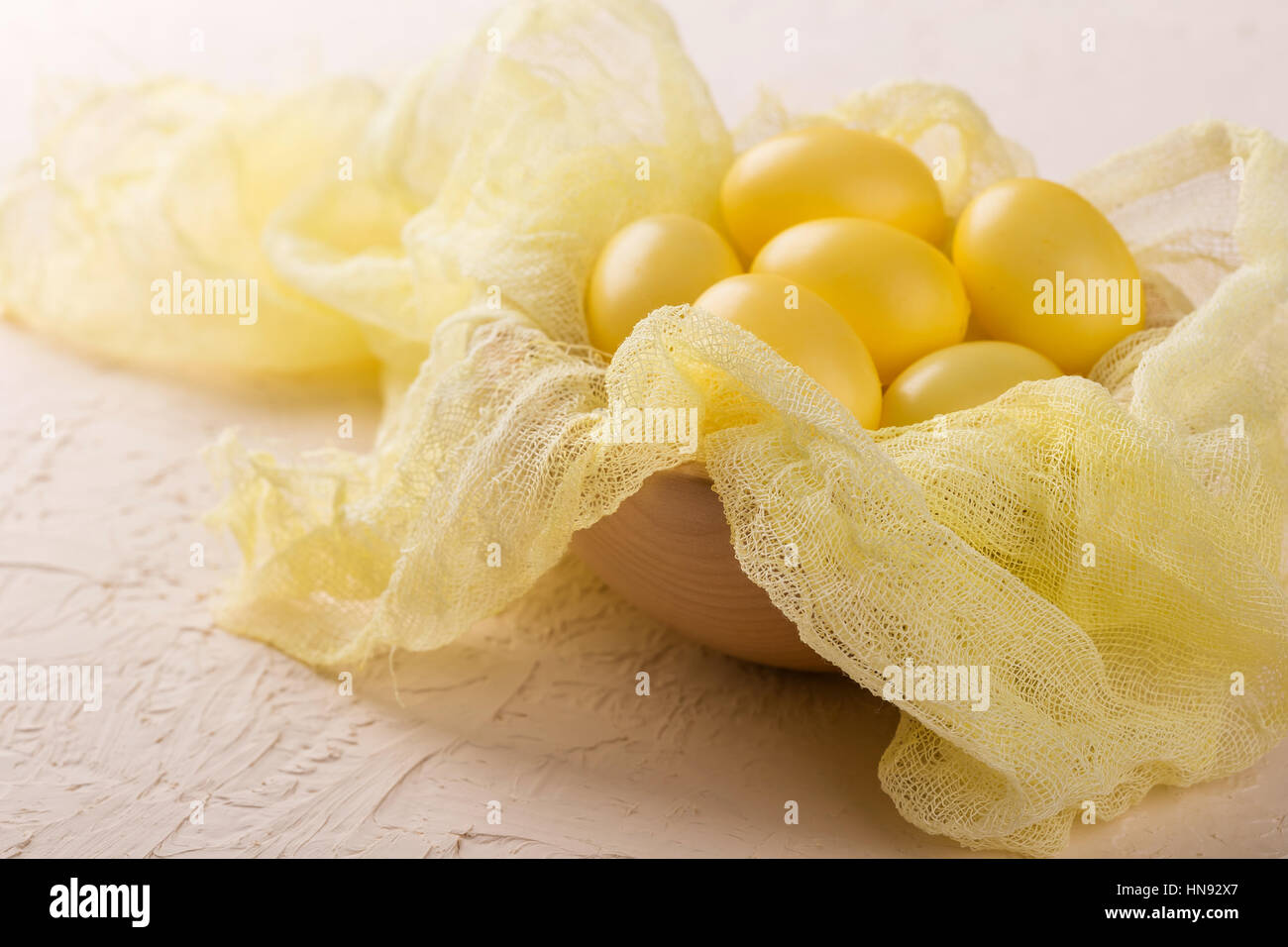 Decoración de huevos de Pascua amarillo en un recipiente de madera Foto de stock