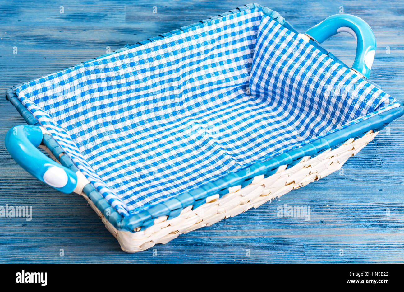 Cesta de Pan de mimbre blanco con tela cuadriculada en backgr azul Foto de stock
