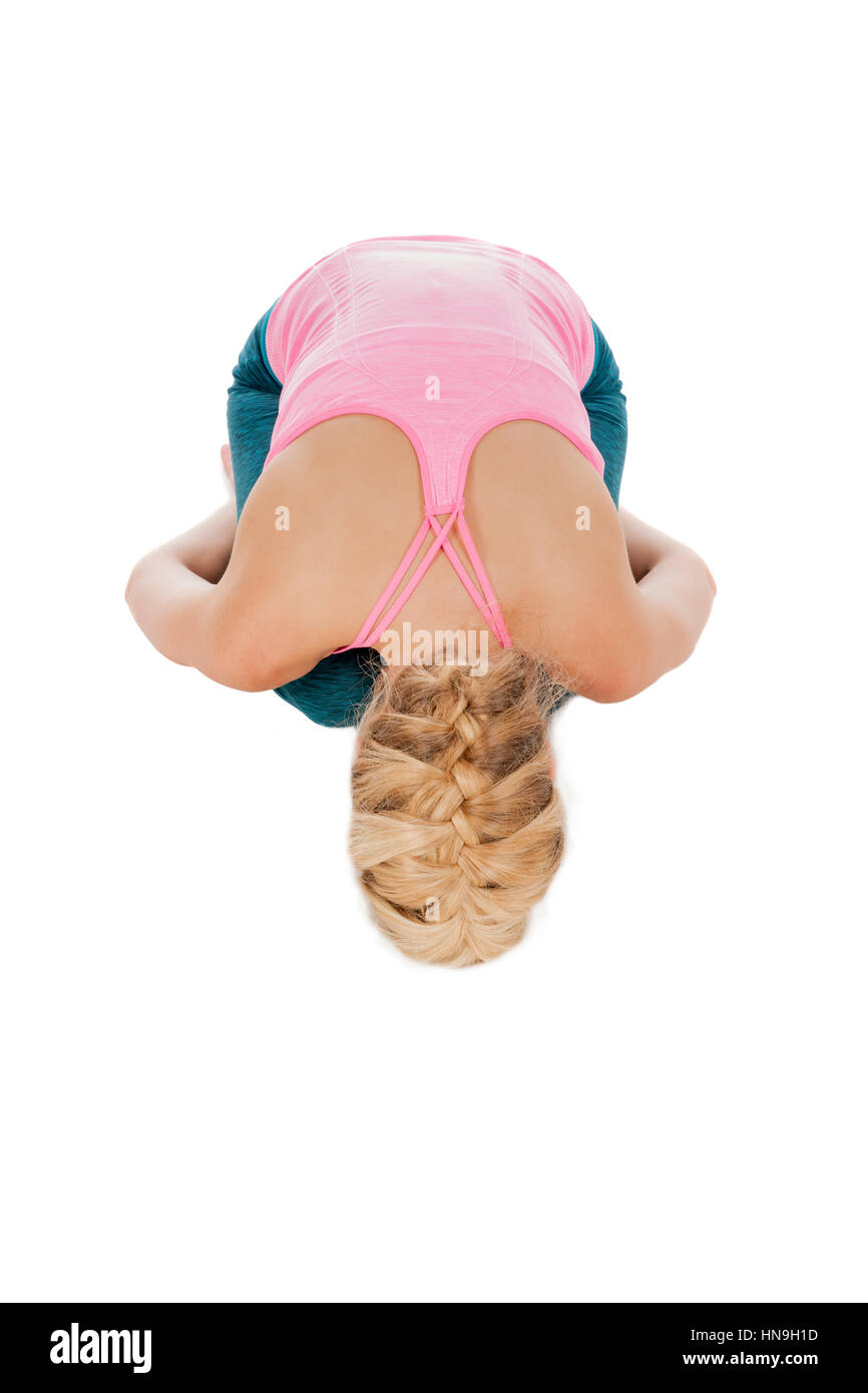 Vista completa del cuerpo de una joven mujer rubia en posición yoga 'Posición del niño ' aislado en blanco en la vista superior. Foto de stock