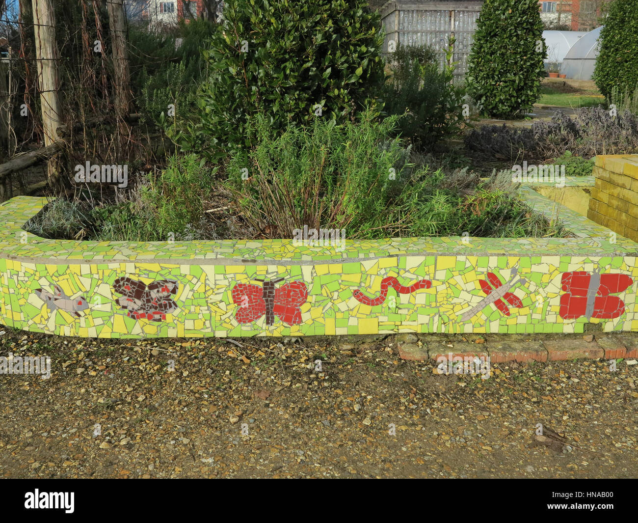 Mosaico de pared verde jardín adornado con mariposas y libélulas Foto de stock