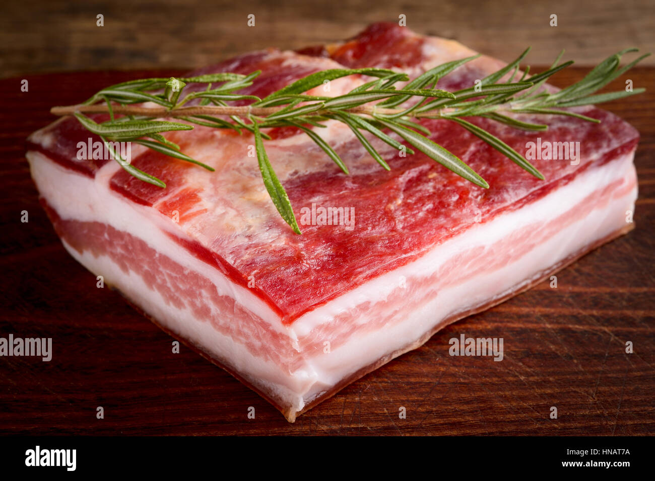 Bacon italiano luppolino sobre una tabla de cortar de madera - comida italiana Foto de stock