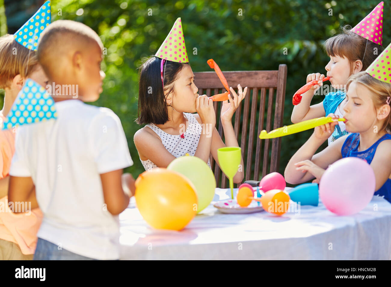 Los niños en la fiesta de cumpleaños en el jardín celebrar juntos con ... - Los Ninos En La Fiesta De Cumpleanos En El JarDin Celebrar Juntos Con Globos Y Matasuegras Hncm2b