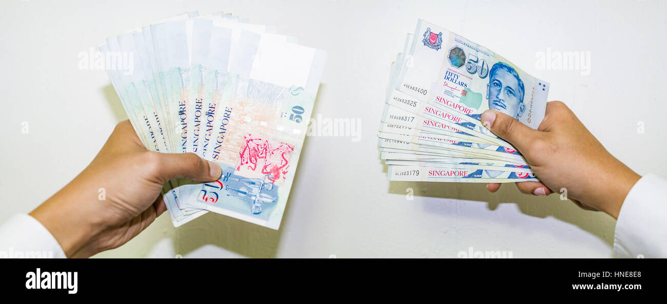 Moneda de Singapur con mano aislados en fondo blanco, el Dólar de Singapur, Singapur billetes, dinero propagación Foto de stock