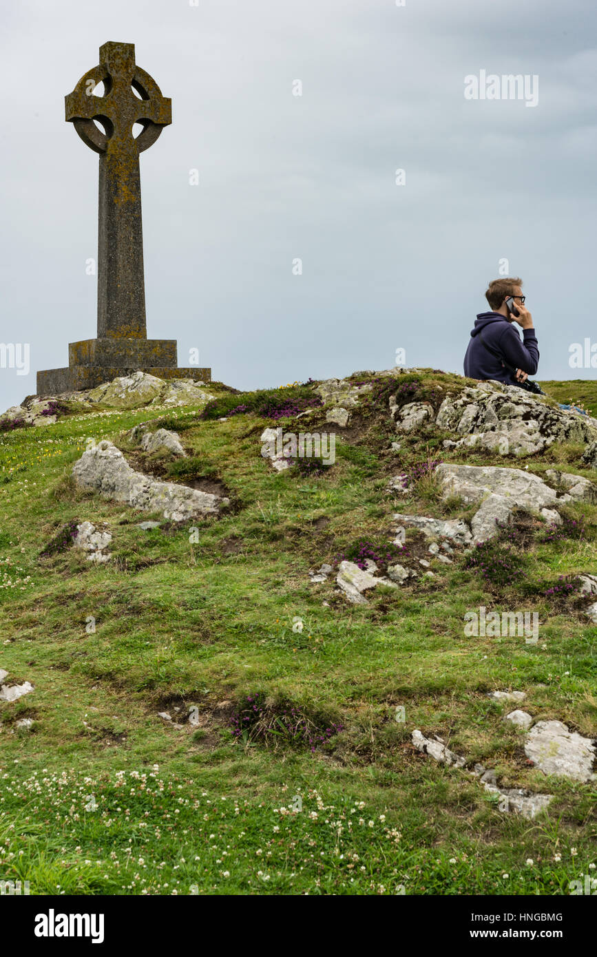 La vida moderna se inmiscuye en una escena espiritual más antigua en la isla Llanddwyn, Anglesey Foto de stock