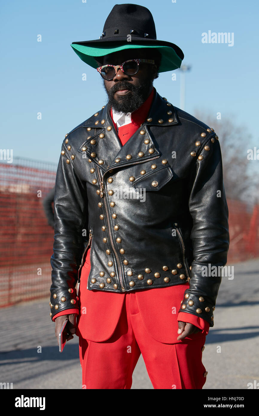 Hombre con chaqueta de cuero negro y pantalón rojos antes de Dirk Bikkembergs Fashion Show, la Semana de la moda de Milán street style en enero Foto de stock