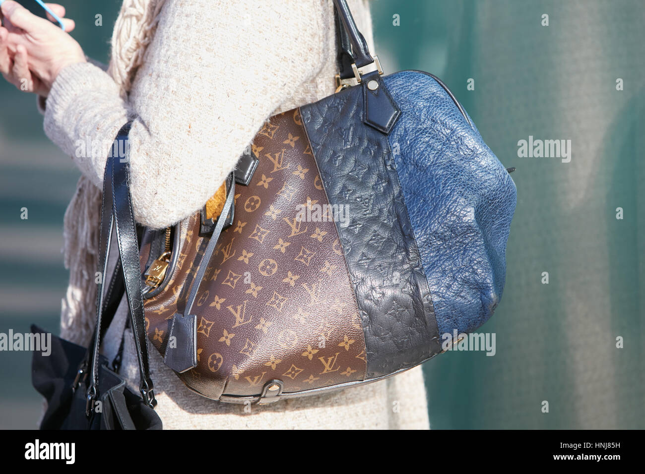 Mujer con bolsa de Louis Vuitton en colores marrones y azules antes de Giorgio Armani Fashion Show, la Semana de la moda de Milán street style Janua Foto de stock