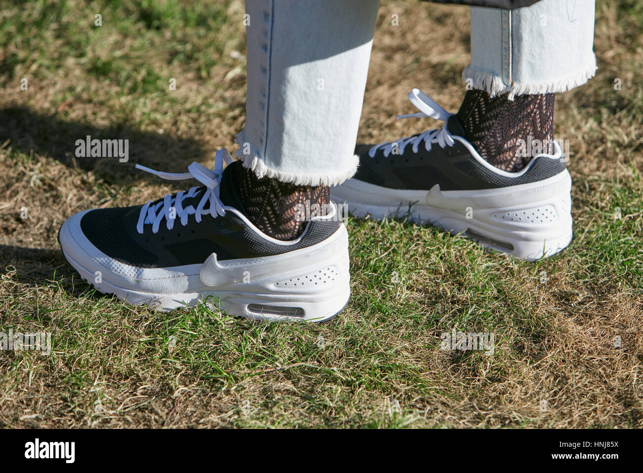 Mujer con zapatillas Nike en blanco y negro antes de Giorgio Armani Fashion  Show, la Semana de la moda de Milán street style el 17 de enero de 2017 en  Milán Fotografía