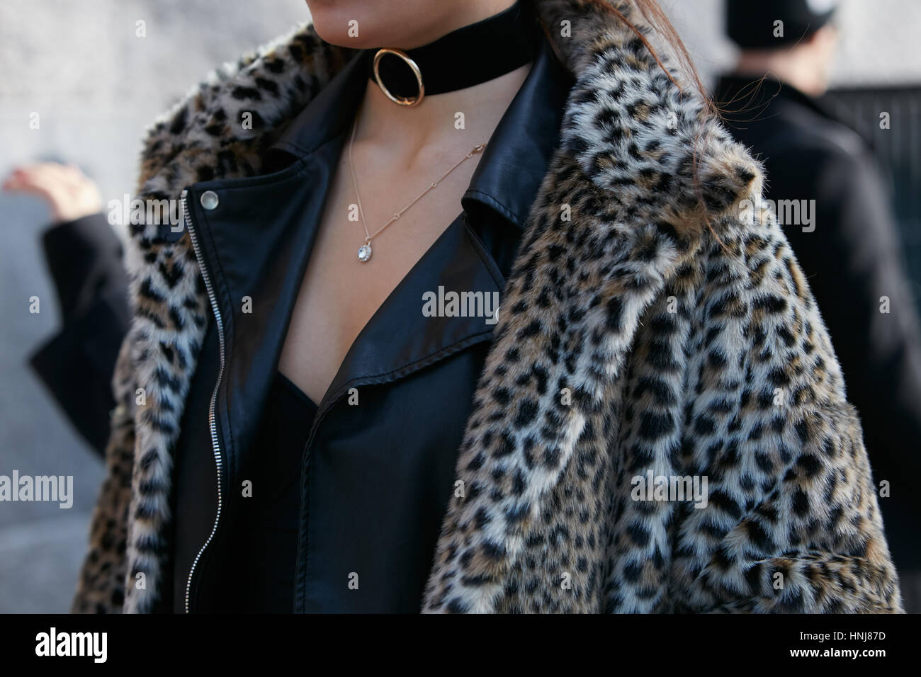 Mujer con abrigo de pieles de leopardo y chaqueta de cuero negro antes de Giorgio Armani Fashion Show, la Semana de la moda de Milán street style en enero de 2017 Foto de stock