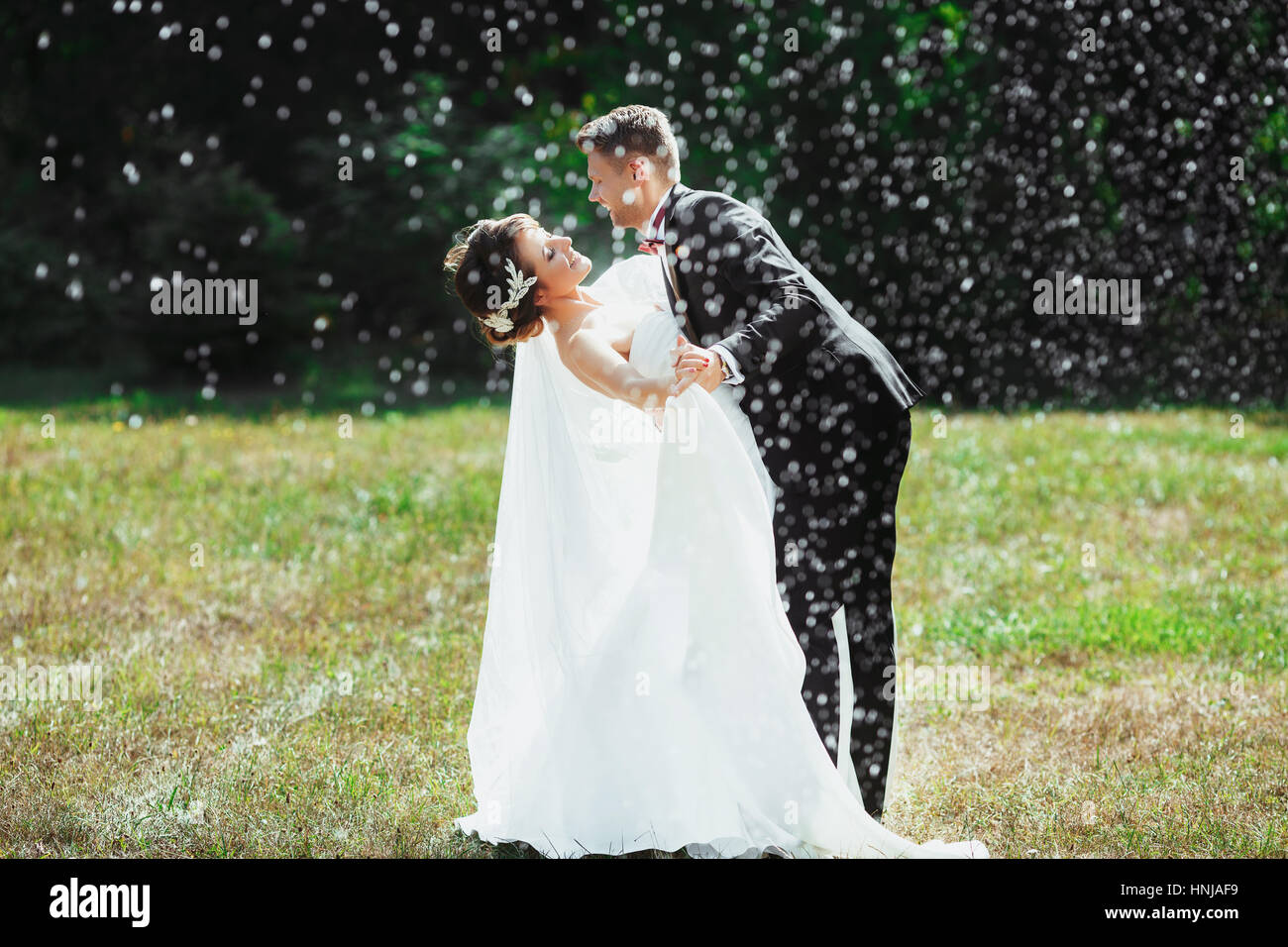 El novio y la novia de pie bajo la lluvia Foto de stock