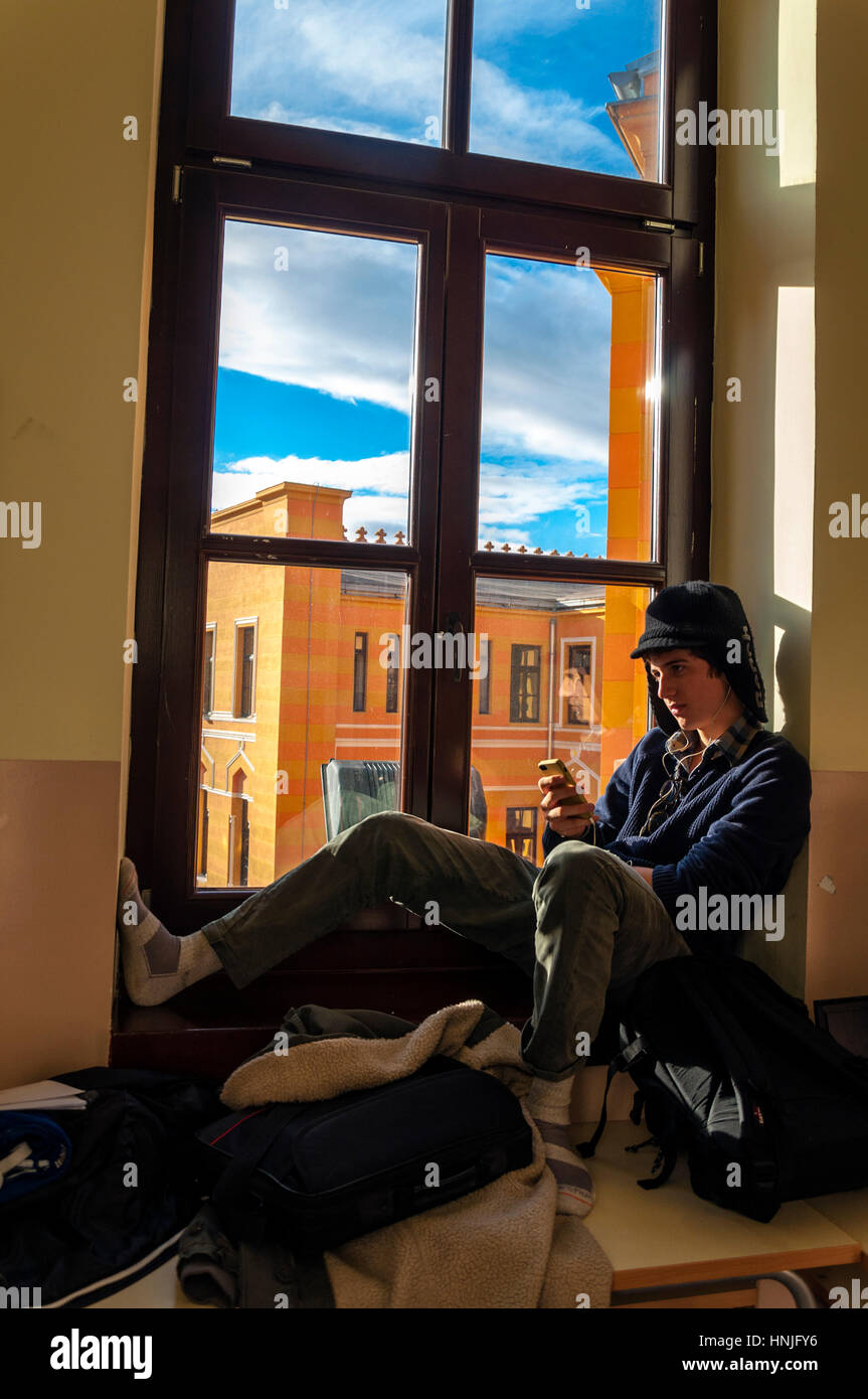 Mostar, Bosnia Herzcegovina, estudiante varón en United World College UWC escuela escuchando música iPhone Foto de stock