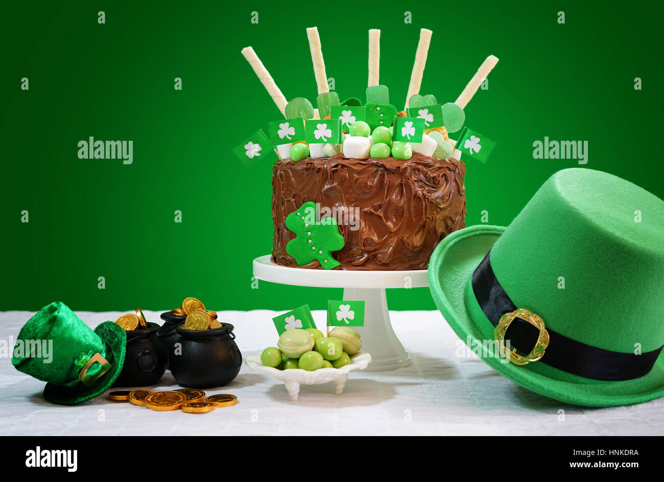 Feliz Día de San Patricio, el 17 de marzo, el partido verde y blanco tabla con impedimento tarta de chocolate decorada con dulces, galletas y shamrock banderas. Foto de stock