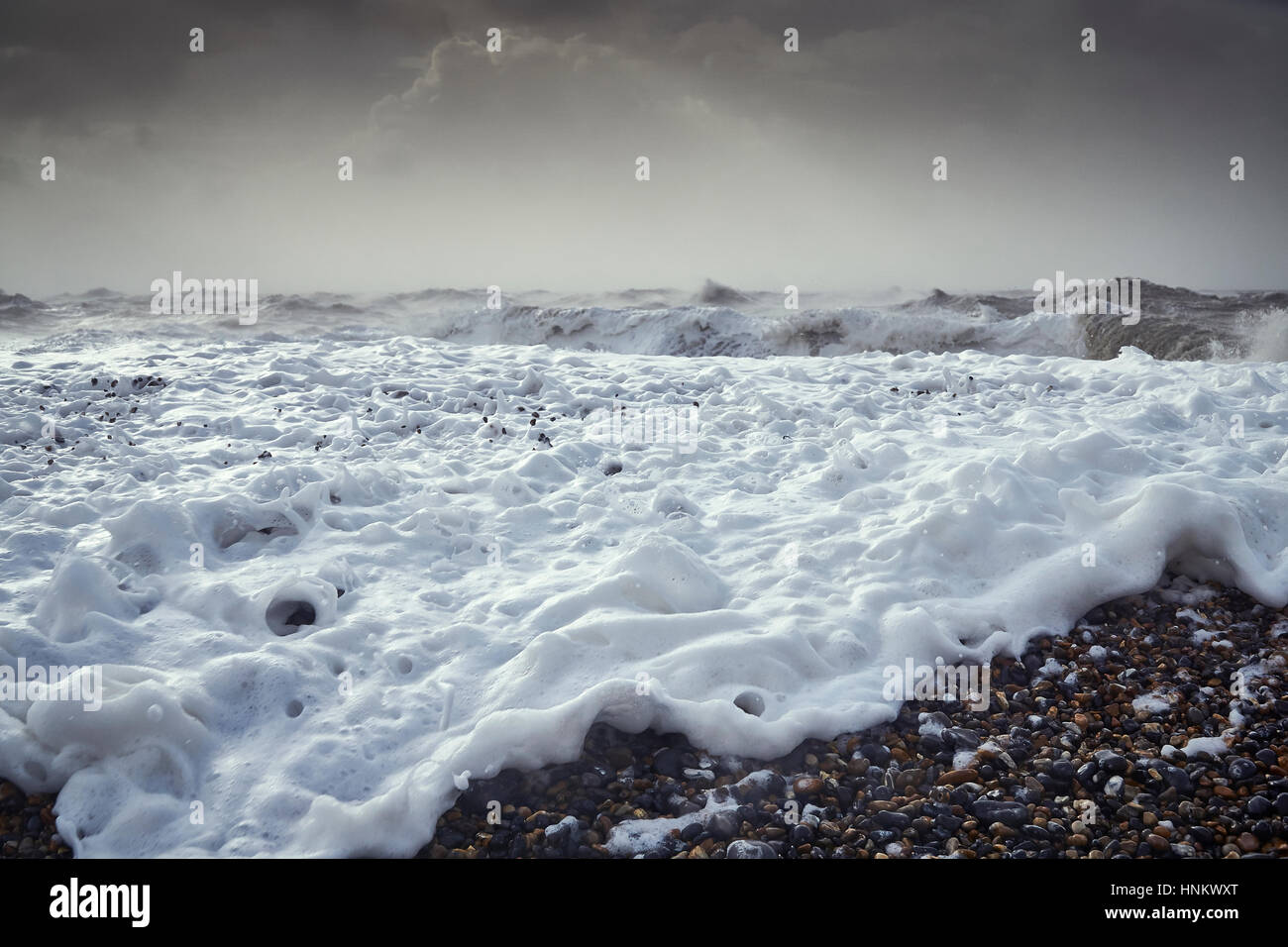 Cerca de una ola rompiendo en una playa de guijarros durante una tormenta Foto de stock