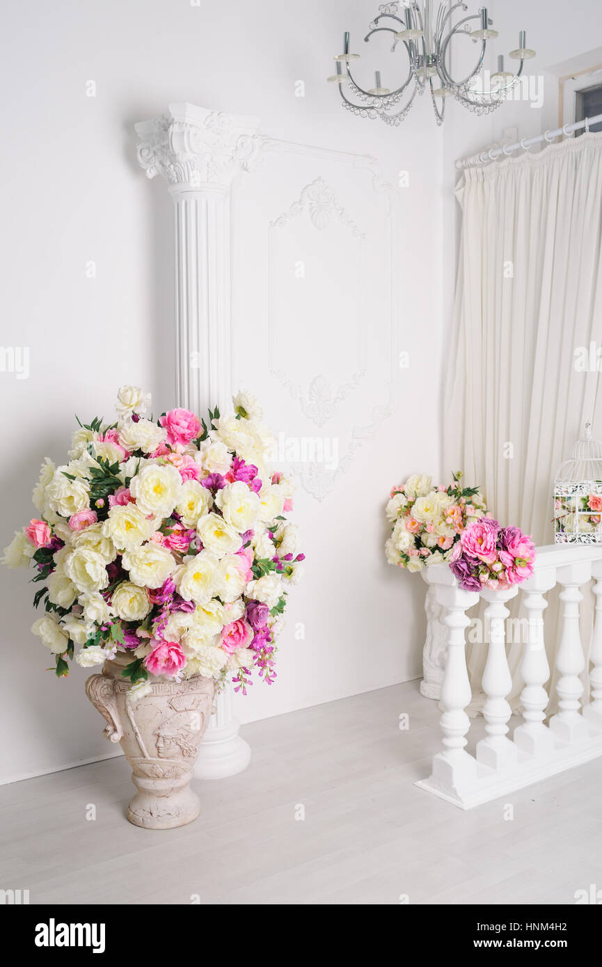 Hermosa decoración de flores en jarrones en blanco studio Foto de stock