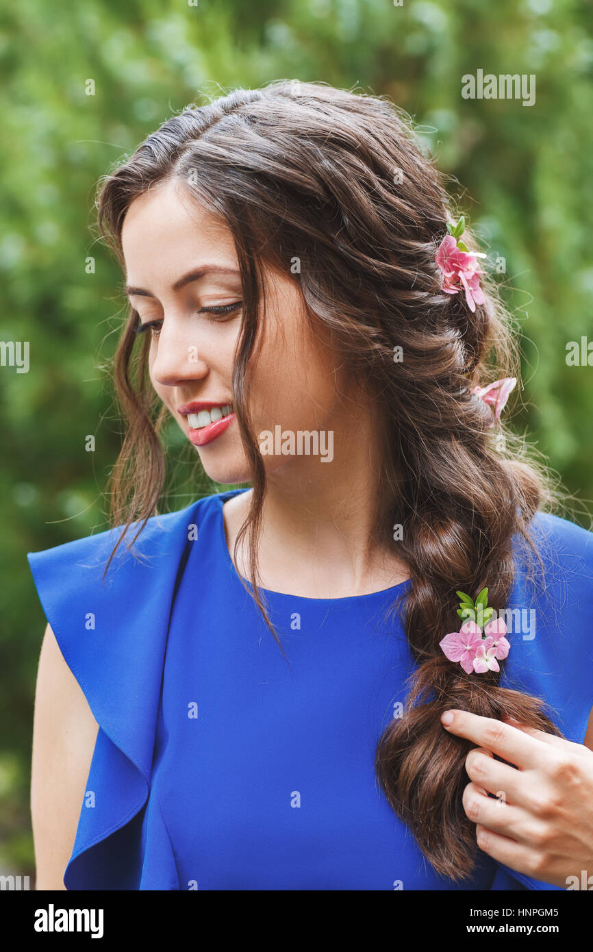 Peinado elegante con flores frescas en una trenza. Retrato de mujer con  peinados de moda para vacaciones en el fondo de la naturaleza. Peinado.  Boda flor Fotografía de stock - Alamy