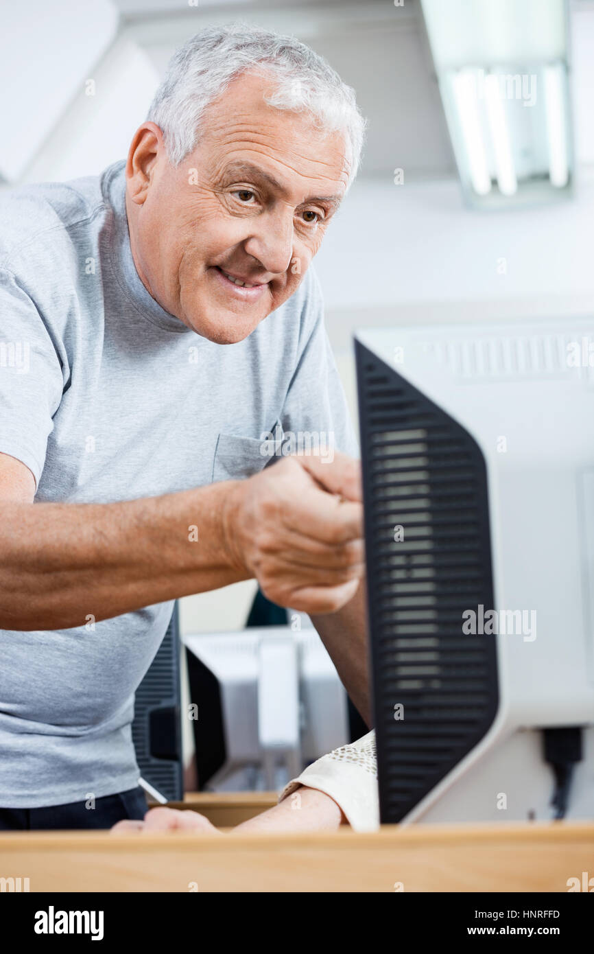 Hombre senior ayudando classmate en el uso de ordenador Foto de stock