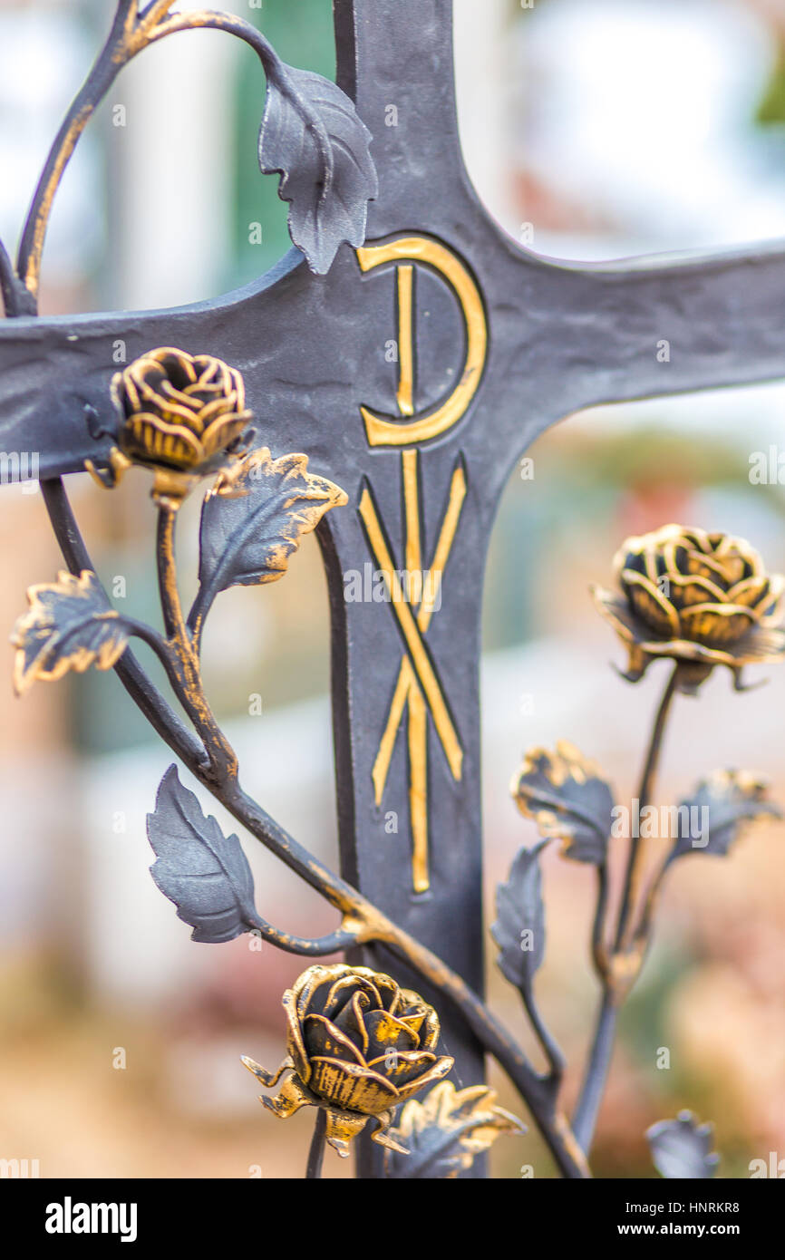 Cruz de hierro católica con rosas y el símbolo de las letras griegas chi y  ro significado Cristo Fotografía de stock - Alamy