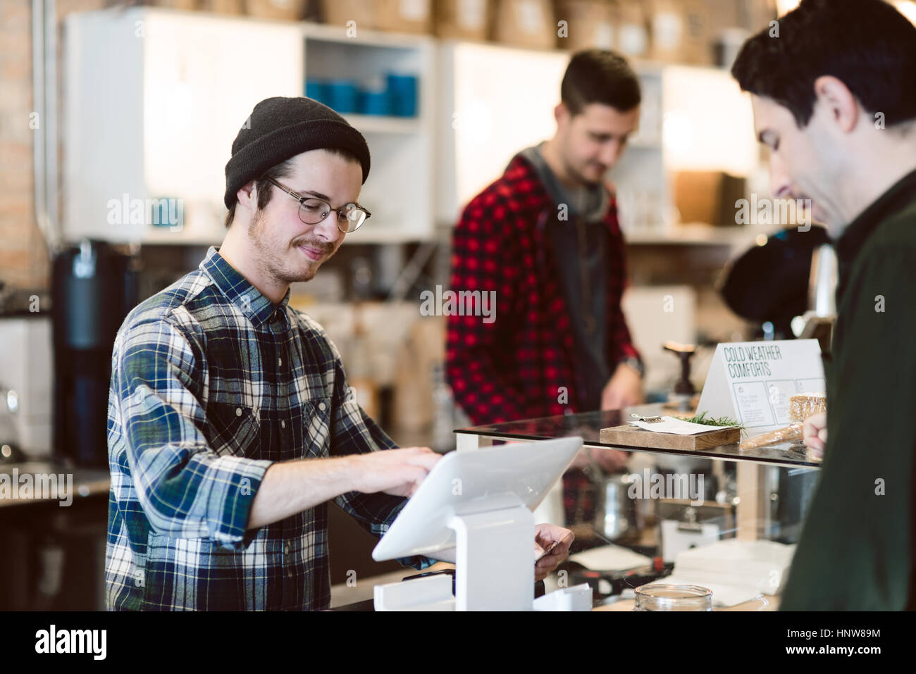 Cajero asistiendo al cliente en cafe Foto de stock