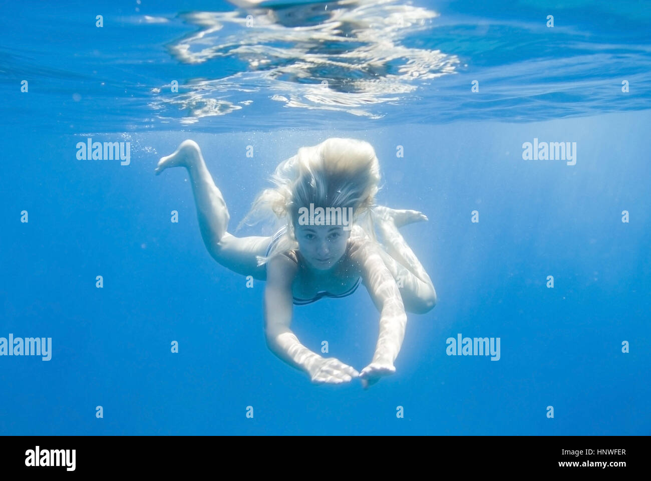 Modelo de liberación, Junge Frau schwimmt unter Wasser - joven bajo el agua. Foto de stock