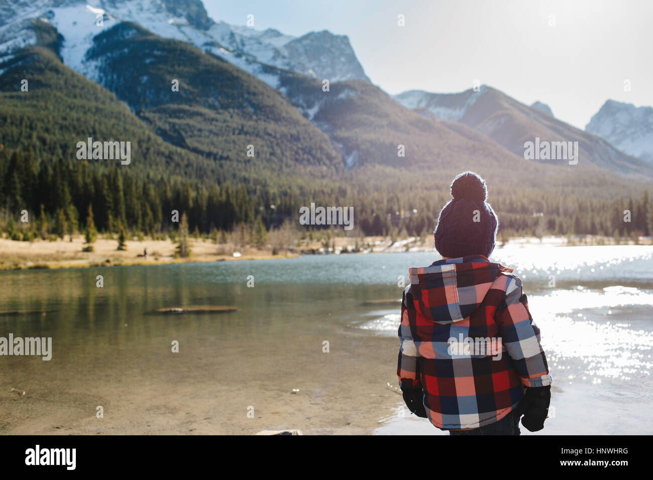 Joven junto al río, vista trasera, Tres Hermanas, Montañas Rocosas, Canmore, Alberta, Canadá Foto de stock