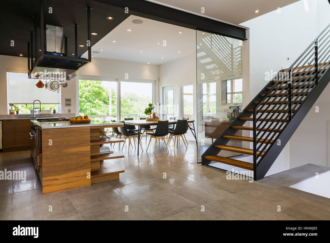 Cocina, comedor y madera de nogal americano y escaleras de acero dentro de  una moderna casa estilo cubo, Quebec, Canadá Fotografía de stock - Alamy
