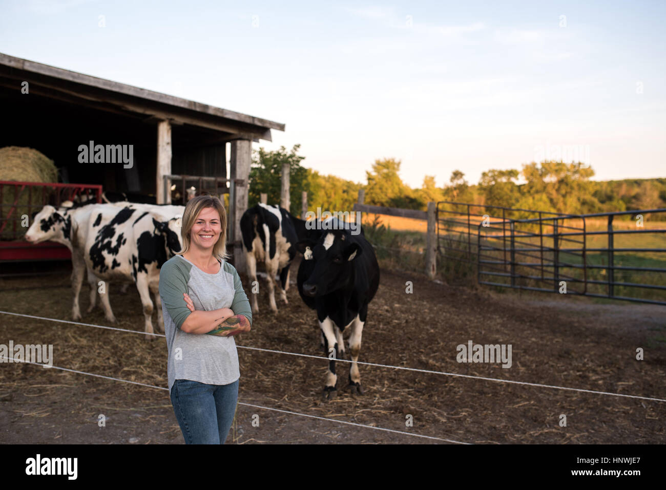 Retrato de la agricultora en la granja, vacas en segundo plano. Foto de stock